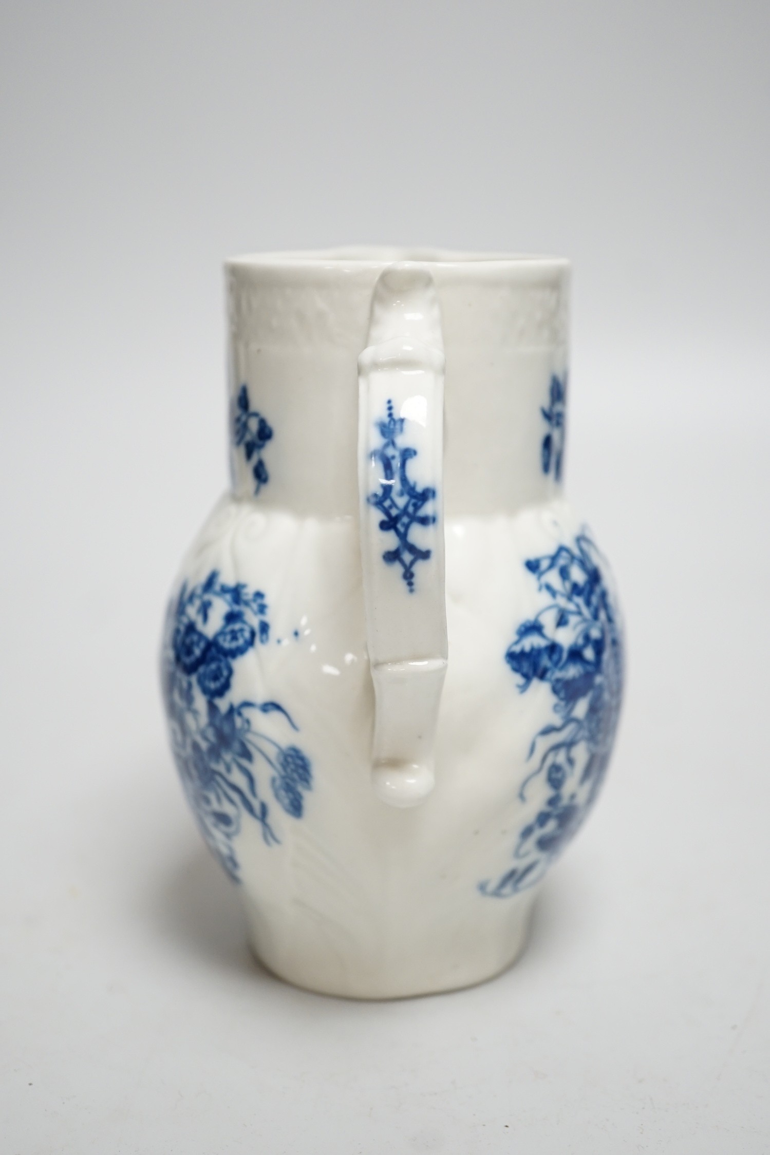 An 18th century Caughley mask jug printed with bouquets, C mark to base, 14.5cms high